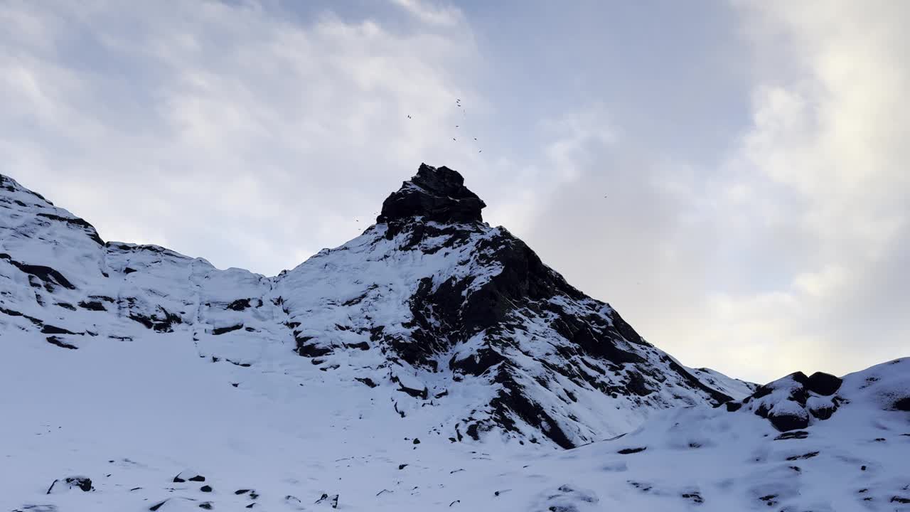 积雪覆盖的山坡下，多云的天空积云视频下载