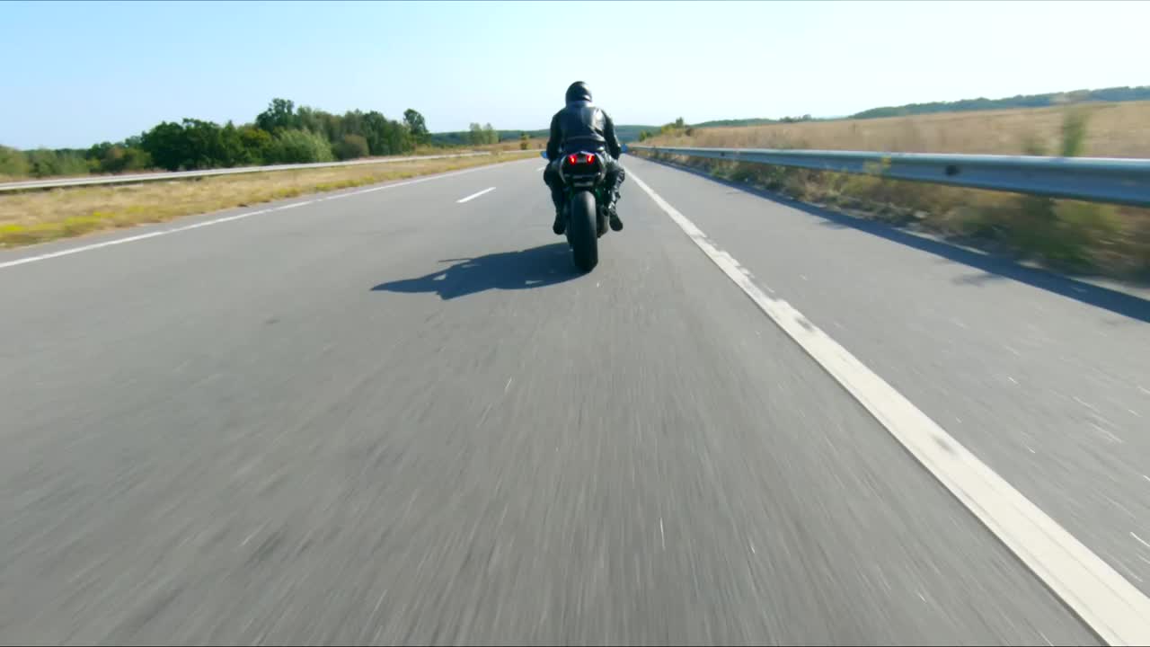 跟随摩托车手在高速公路上骑着现代运动摩托车。骑摩托车的人在乡间公路上驾驶摩托车。旅途中骑自行车的人。在旅途中自由和冒险的概念。空中拍摄视频下载