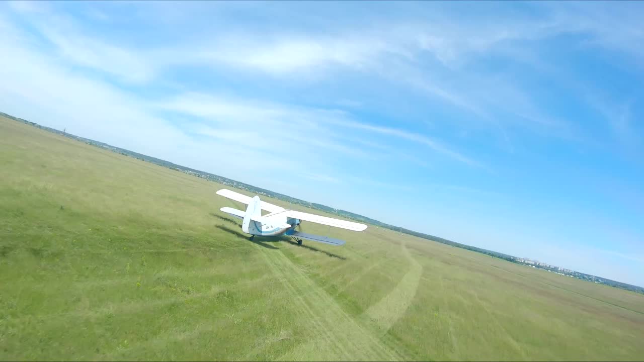 飞机在起飞前沿着乡村跑道行驶。在机场飞行前，旧飞机正朝着简易跑道前进。复古飞机准备飞行。航空的概念。无人机航拍视频下载