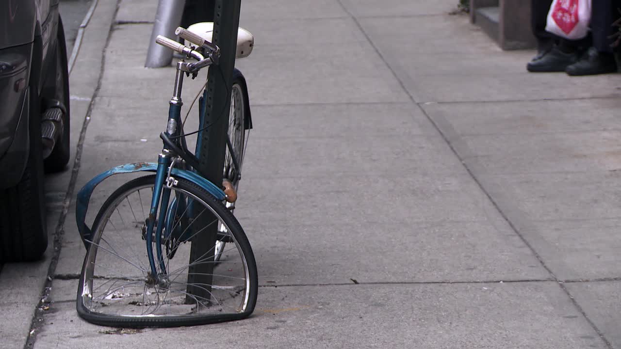 用铁链拴在城市街道上的一辆脱光的自行车视频下载