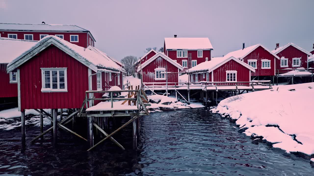罗弗敦群岛，挪威，莱因，红色的房子渔村在一个冬天的雪天的海边视频下载