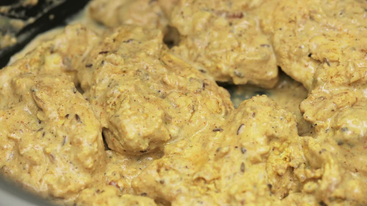 米饭倒在腌制过的鸡肉上，准备印度菜鸡肉香饭的过程视频下载