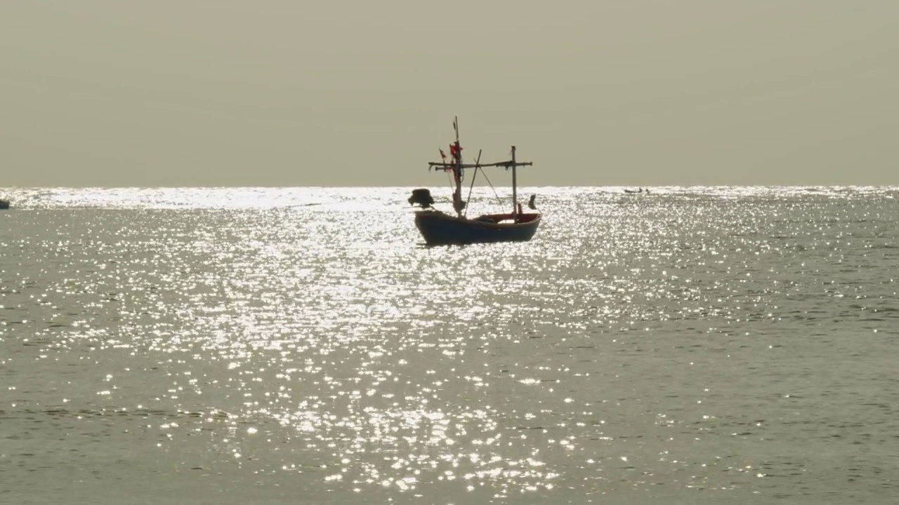 海上的渔船，金色的水面反射在阳光下闪闪发光视频下载