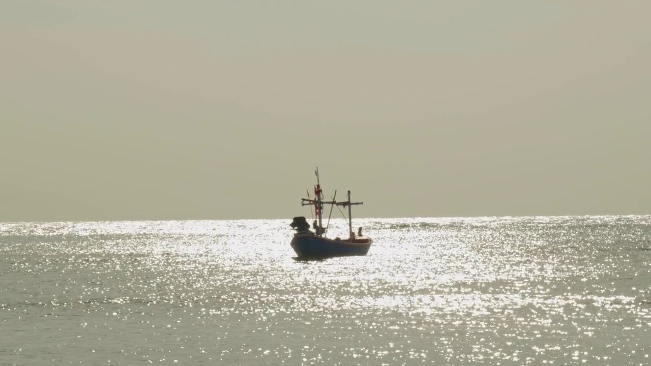 海上的渔船，金色的水面反射在阳光下闪闪发光视频下载