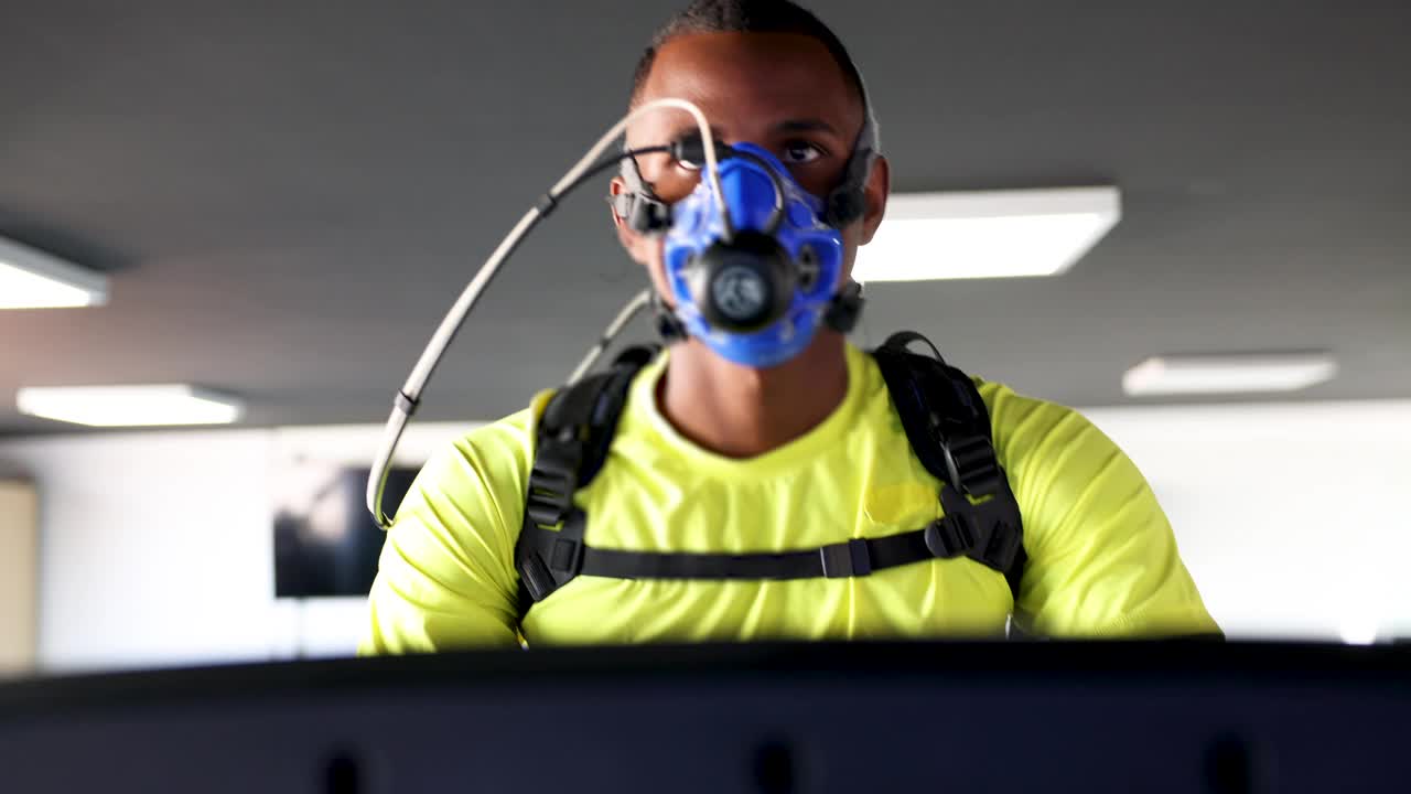 一名黑人运动员戴着所有的监测设备在跑步机上进行人体肺活量测定视频下载