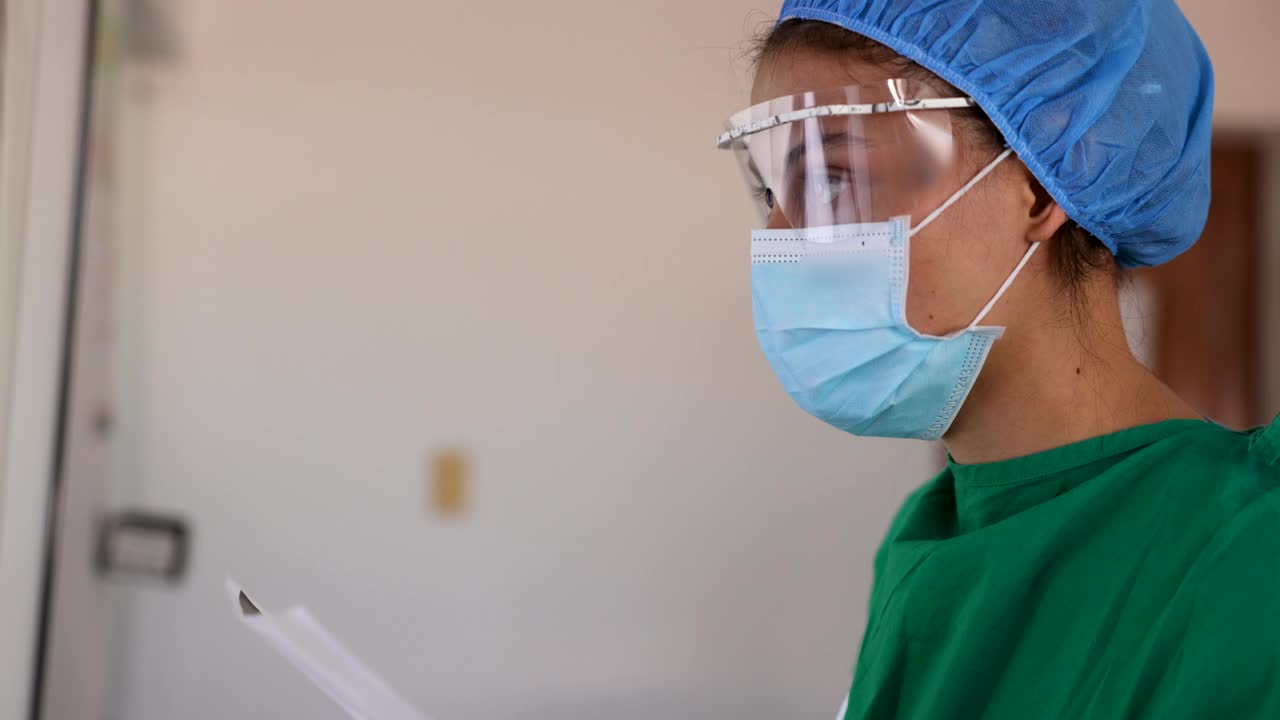 在外科手术过程中，女医生一边对比x光片，一边看着另一张x光片视频下载