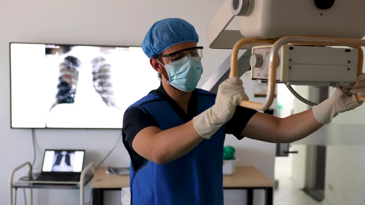 男放射科医生正在调整机器，为躺在手术台上的病人拍x光片视频下载