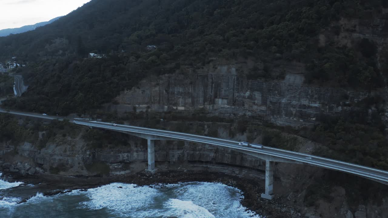 空中向前拍摄的汽车行驶在著名的海崖桥上的山脉-卧龙岗，澳大利亚视频素材