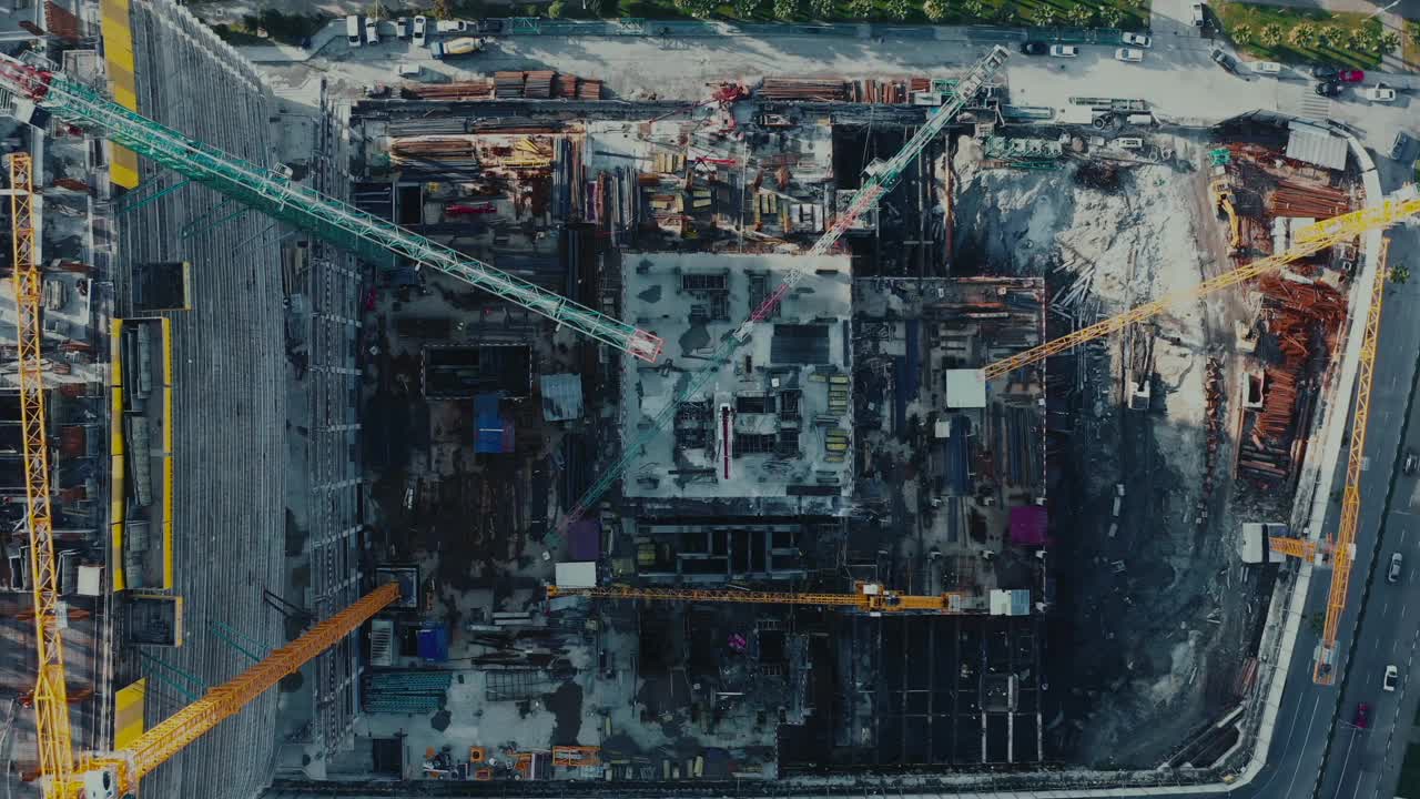大型建筑工地鸟瞰图，有多台起重机、机械和施工活动视频下载