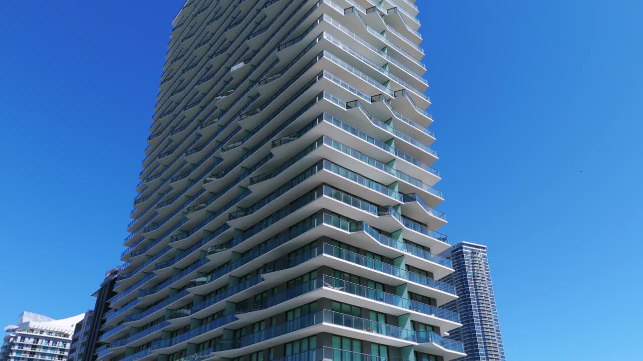 现代建筑高层建筑，设计独特，美观，衬着湛蓝的天空。建筑立面上有多个楼层和线条视频下载
