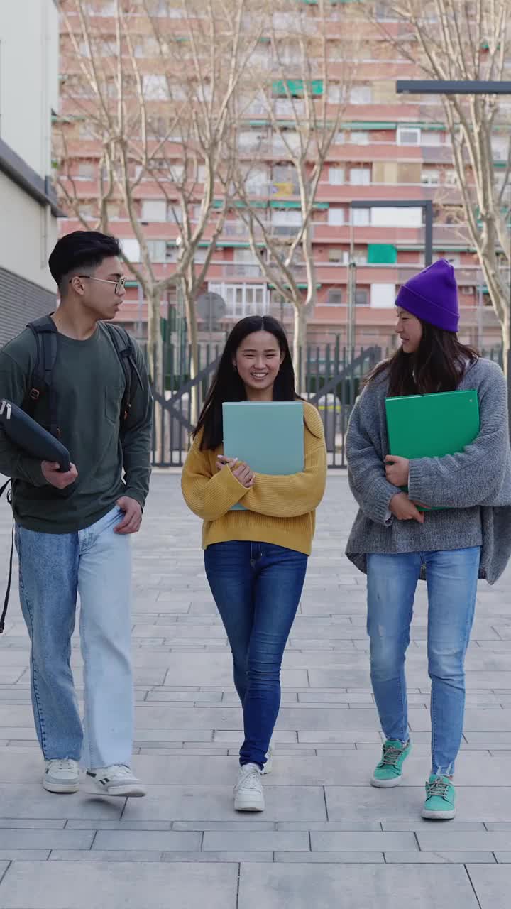 快乐的亚洲学生走在大学校园里视频素材
