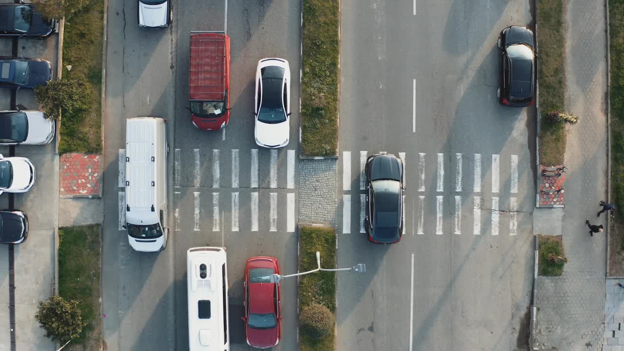 城市街道布局中汽车交通和人行横道的无人机俯视图视频下载