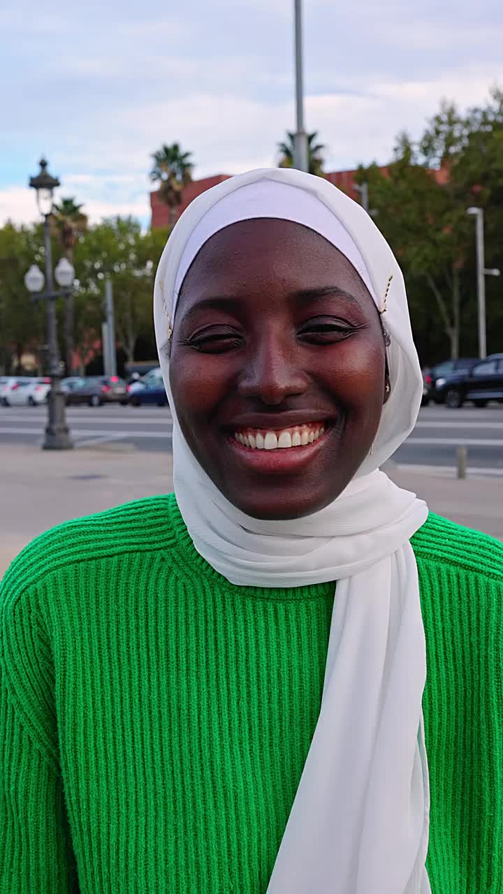 戴着头巾的年轻黑人穆斯林妇女在户外对着相机微笑视频下载
