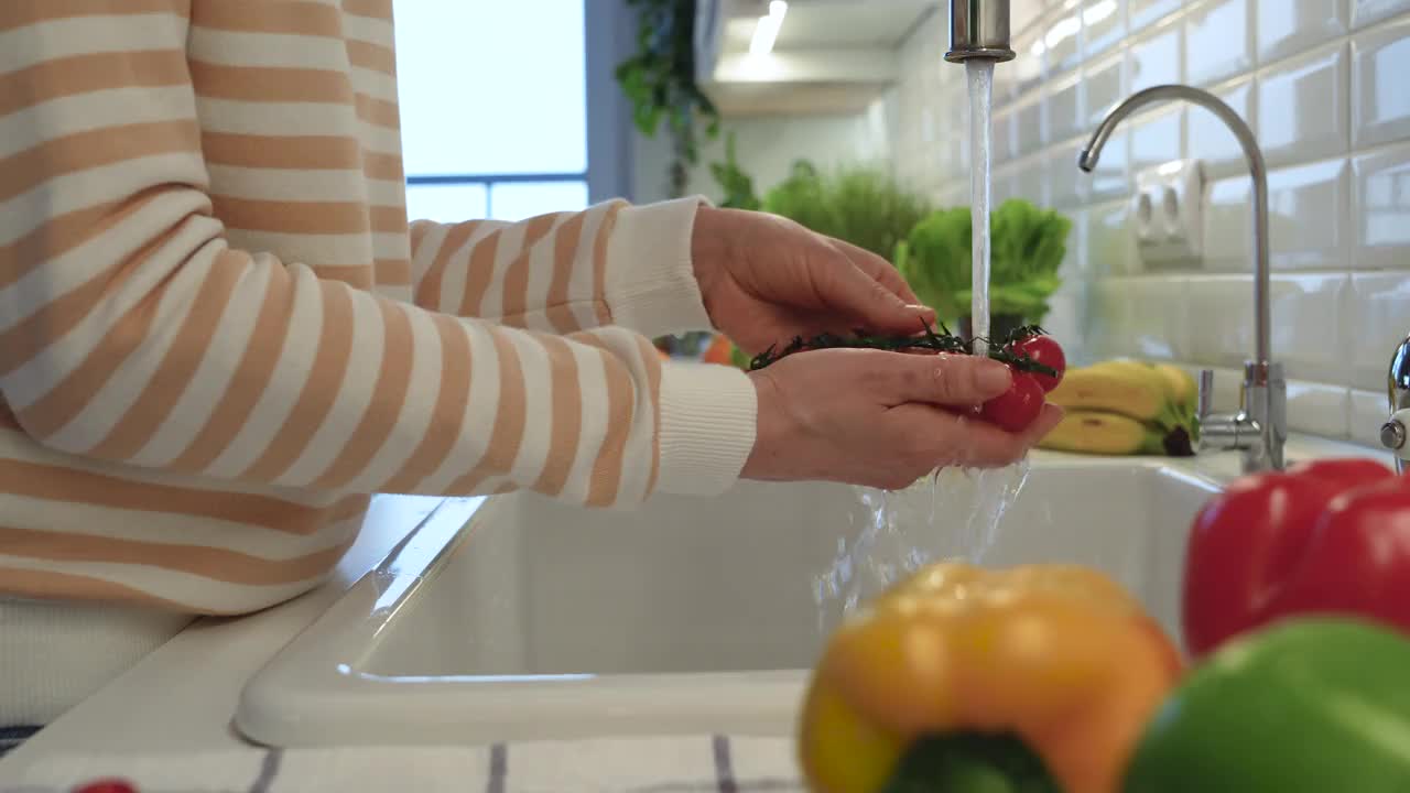 一名妇女正在为沙拉清洗新鲜的圣女果。维生素食品有利于健康和控制体重视频下载