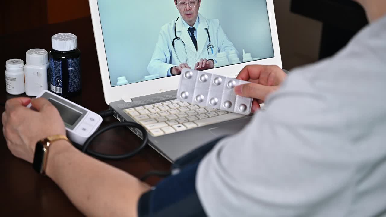 男性患者使用笔记本电脑接受远程医疗视频下载