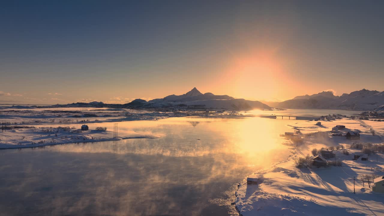 航拍日落的冬季景观，罗弗敦岛的海岸线与挪威雪山丘陵冻结的岩石海滩，挪威视频下载