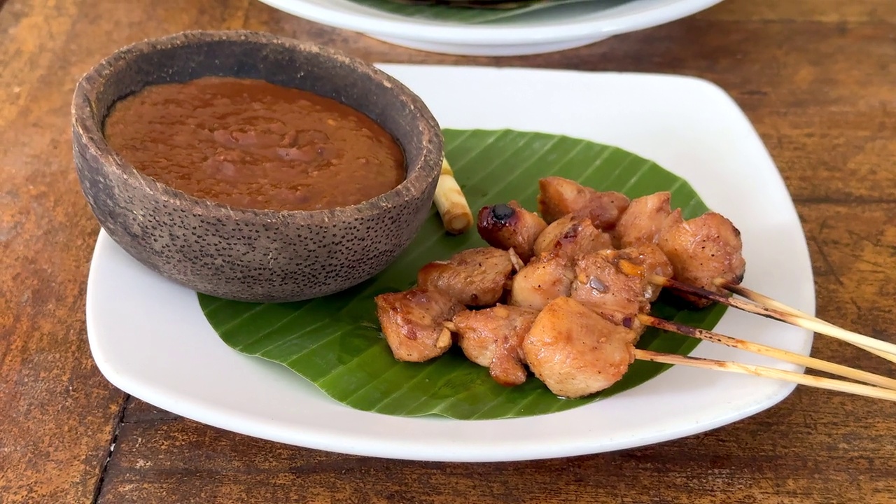 美味的鸡肉沙茶条和花生酱放在香蕉叶上，这是巴厘岛的传统午餐视频下载