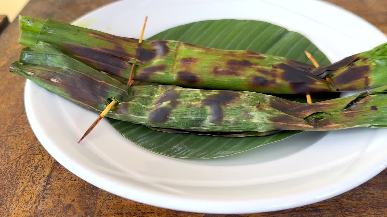传统的巴厘岛食物美味的鸡肉沙茶条和香蕉叶烤金枪鱼炒面，午餐供应视频下载