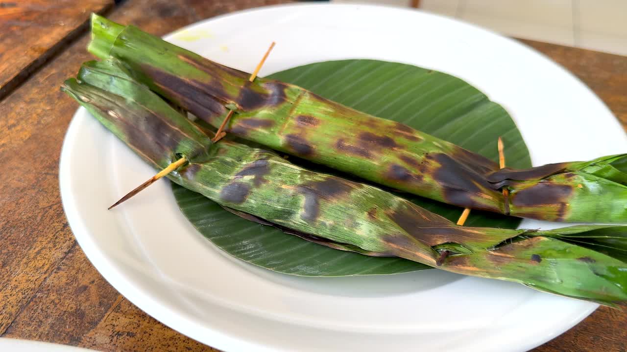 传统的巴厘岛食物，美味的沙茶鸡串和香蕉叶烤金枪鱼炒面，作为午餐视频下载