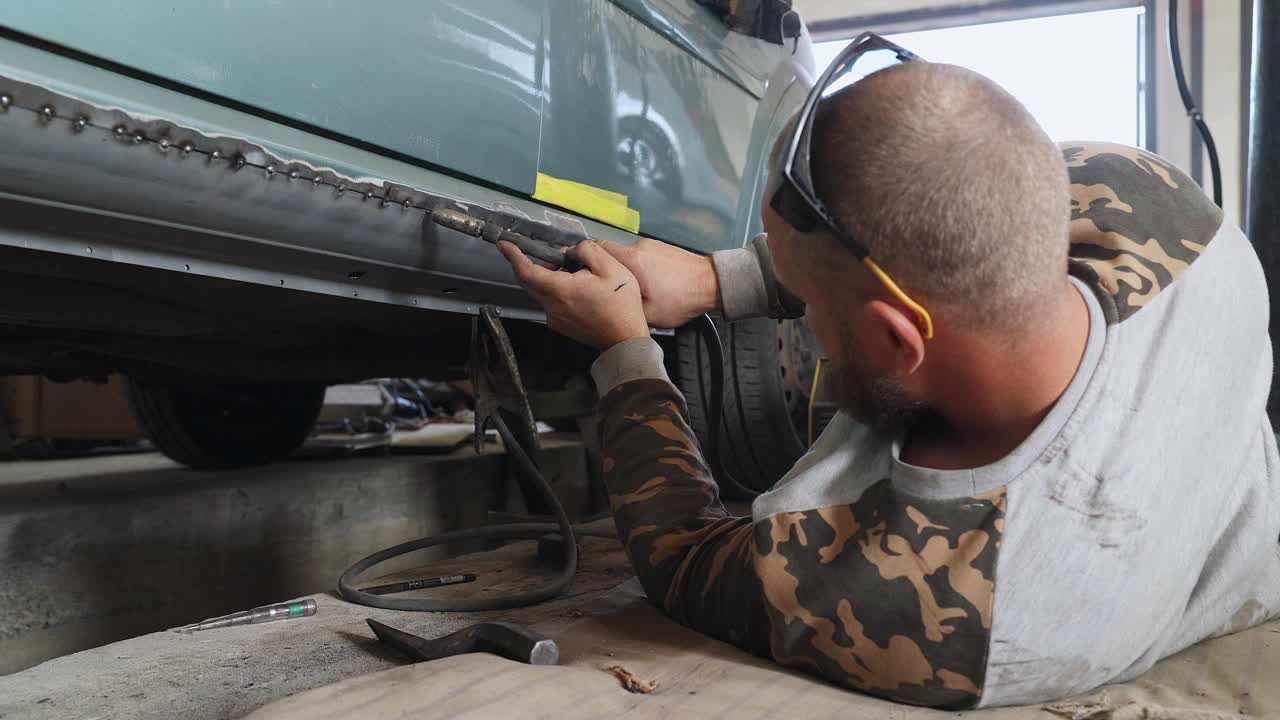机械师把一个新门板焊接到汽车上。视频下载