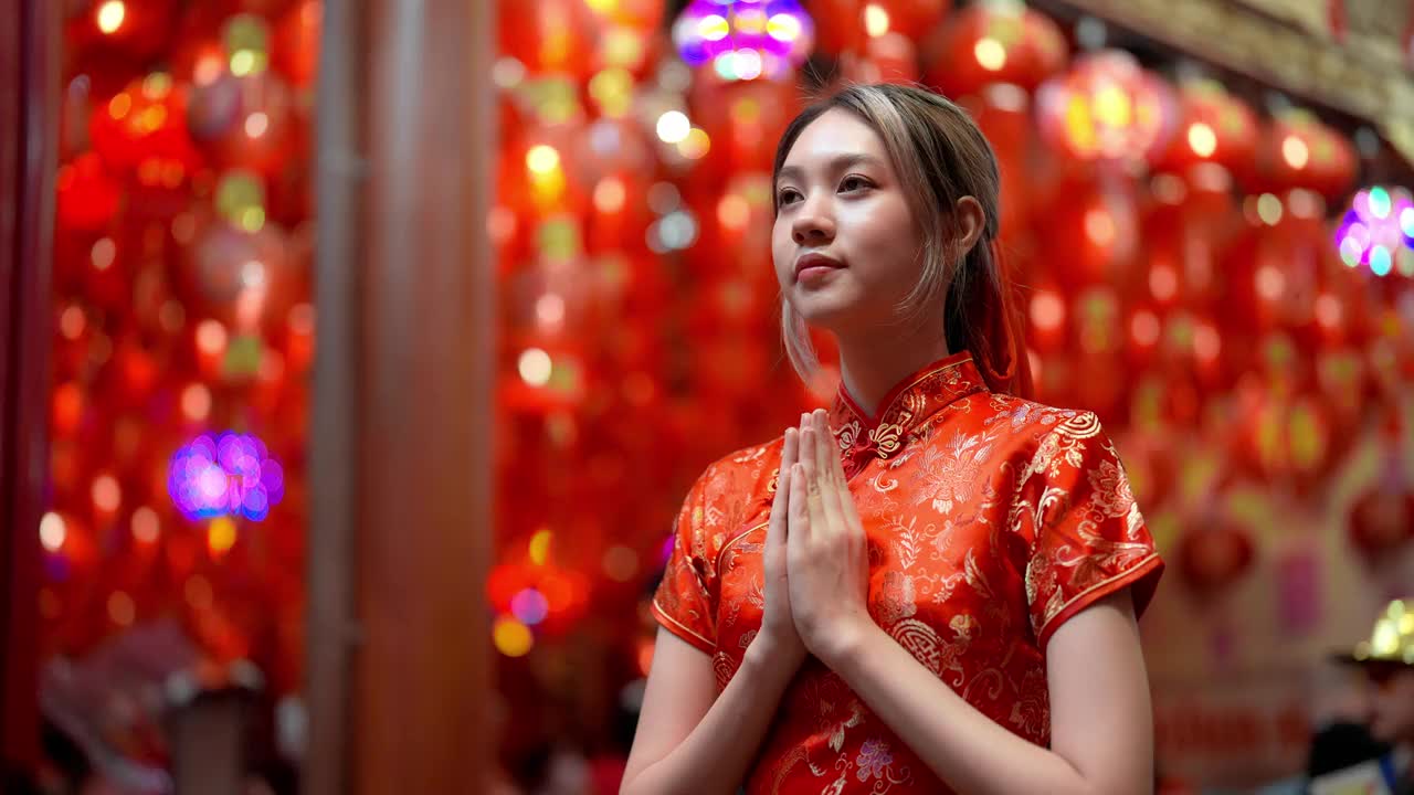 亚洲年轻女孩在寺庙里用灯笼装饰新年时向佛陀祈祷。视频下载