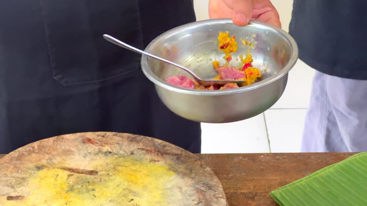 一名厨师将生金枪鱼、辣椒、大蒜、生姜和其他食材混合在一个搅拌碗里视频下载