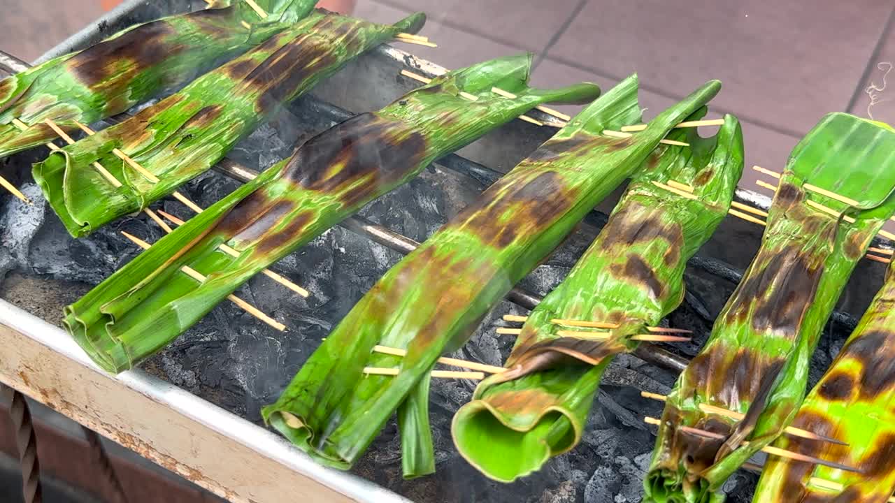在巴厘岛传统烹饪中，炭火升起的烟，用香蕉叶在炭火上蒸金枪鱼视频下载