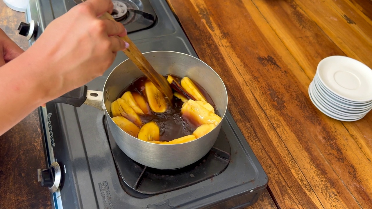 一位家庭厨师搅拌大蕉和糖浆，准备一道传统的印尼甜点视频下载