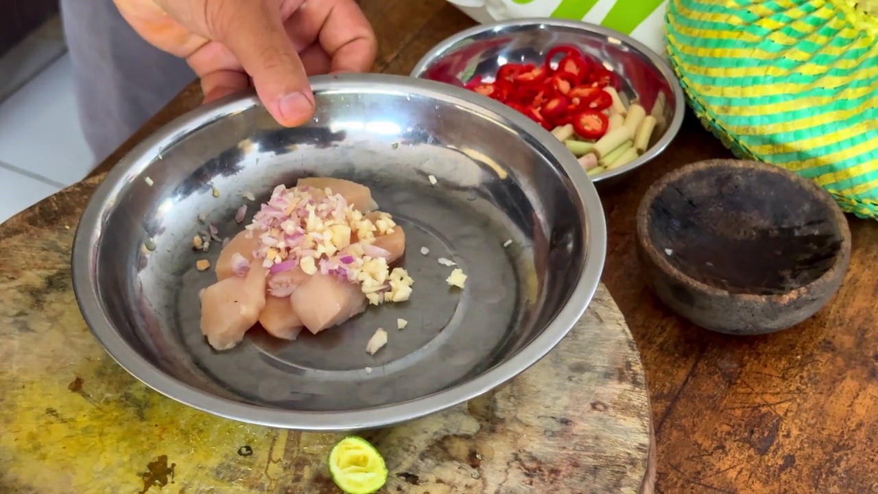 用洋葱、大蒜、盐和胡椒调味生鸡肉，准备与酱汁混合，在传统的印度尼西亚餐中制作沙茶串视频下载