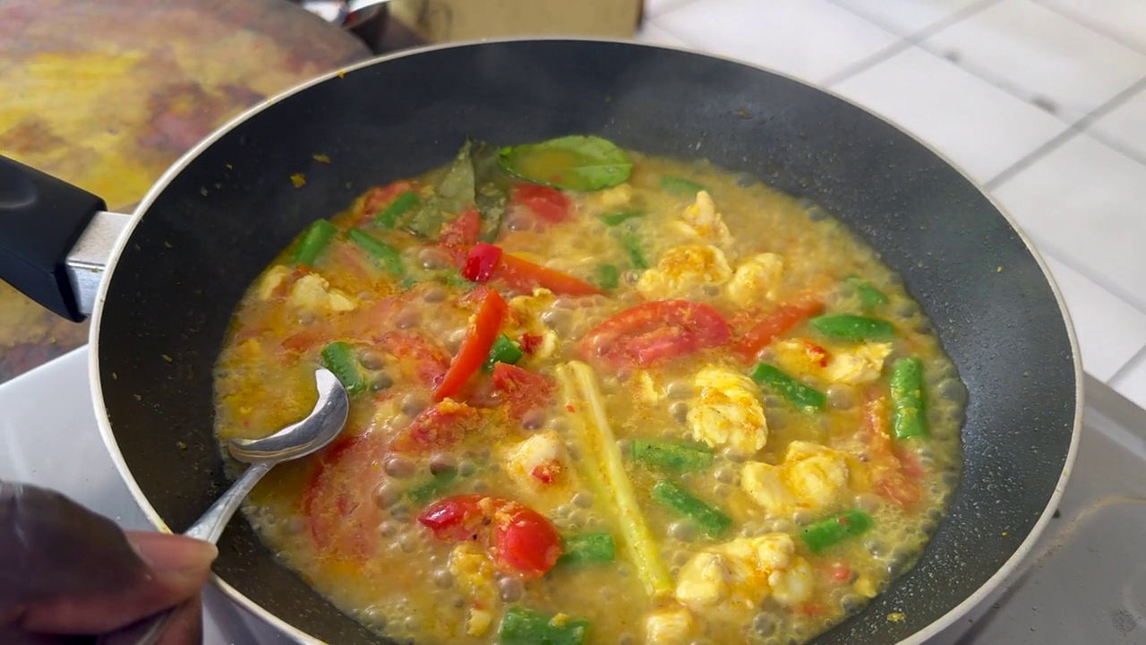 厨师品尝美味的印尼鸡肉和蔬菜椰子咖喱炖在煤气灶上视频下载