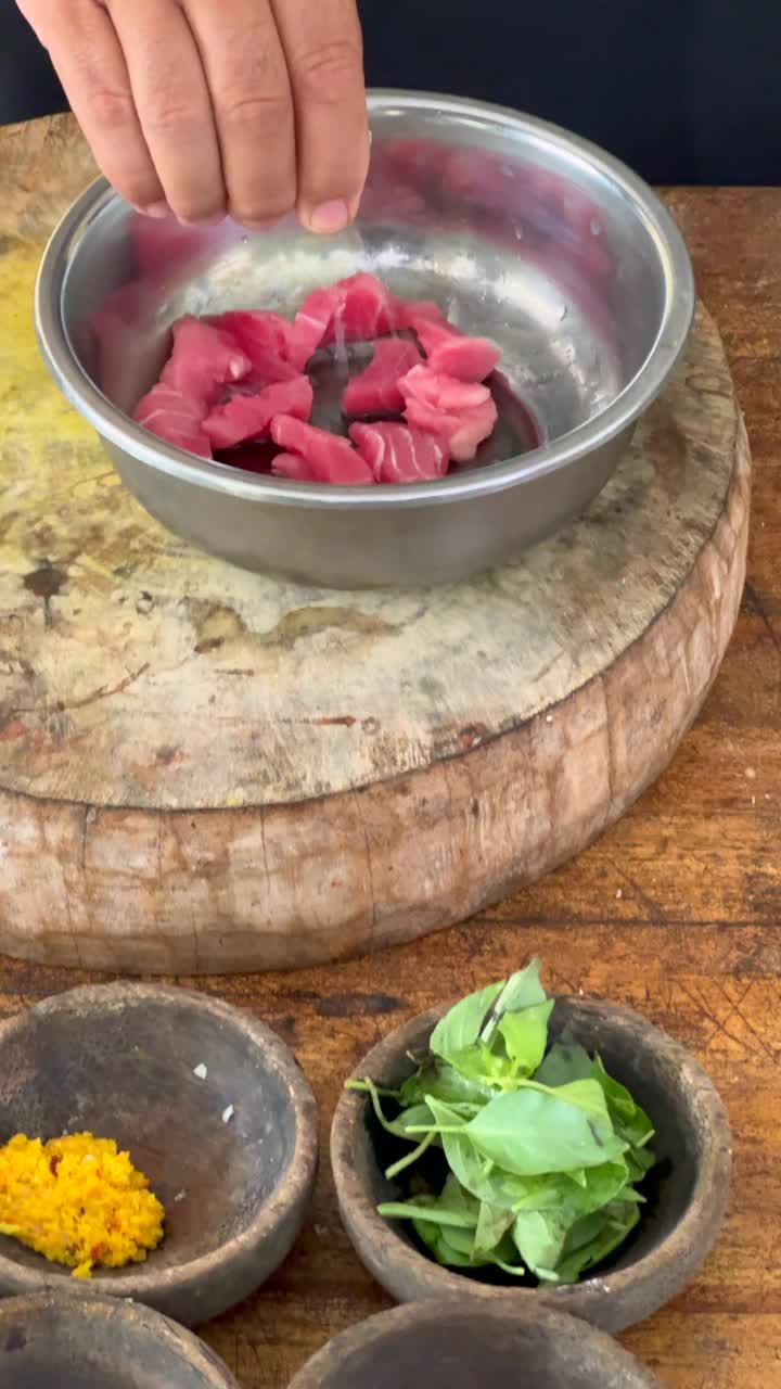 一名厨师将酸橙榨到新鲜的金枪鱼上，并准备其他食材，制作一道美味的巴厘岛传统美食视频下载