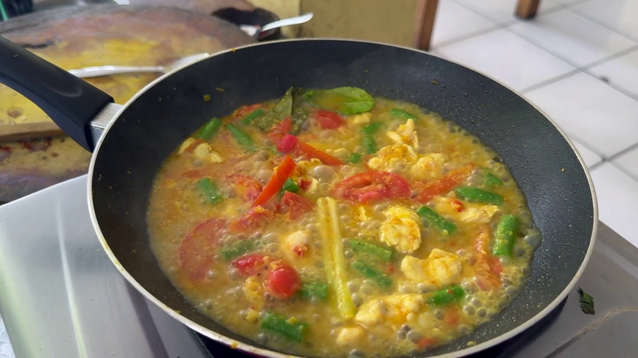 美味的印尼鸡肉和蔬菜椰子咖喱炖在煤气灶上视频下载