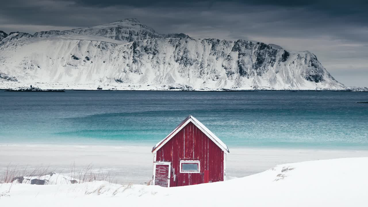 挪威罗弗敦群岛的海滩海岸和雪山上的挪威红房子视频下载