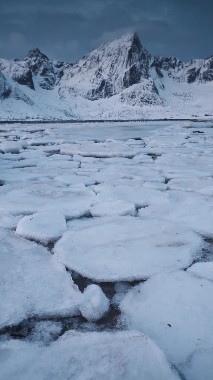 冬季海面景观垂直冻结海岸海滩岩石，峡湾山峰挪威罗弗敦群岛视频下载
