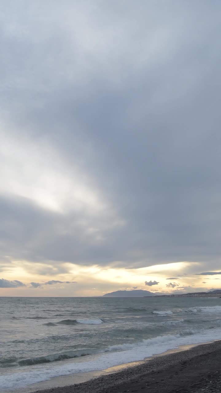 海滩上的日落。4 k垂直视频下载