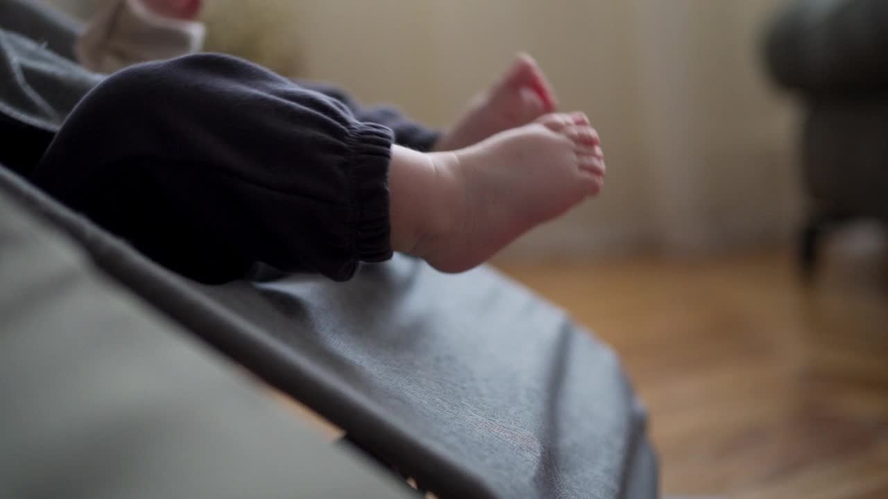 新生儿的脚放在摇摇篮上的特写镜头视频下载