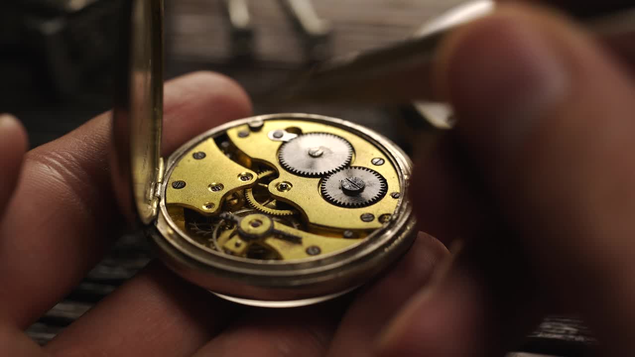 钟表匠拿着古董怀表。机械表维修视频下载