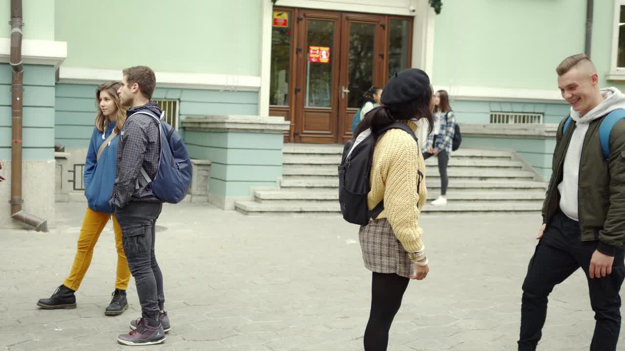 年轻的学生在大学门口谈话视频素材