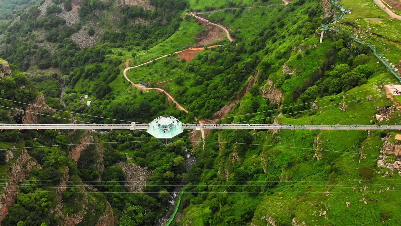 格鲁吉亚，Dashbashi——2022年6月19日:空中飞行在格鲁吉亚乡村风景优美的Dashbashi山谷玻璃桥上的钻石形平台上。高加索山谷上著名的现代桥梁视频下载