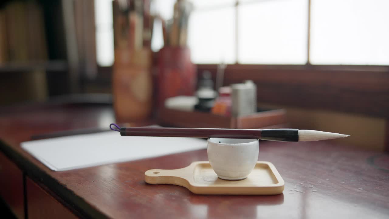 笔刷，墨水和工具，日本书法在桌子上与创意复古文化，工艺和禅宗在家里。画笔，油漆和传统的脚本和桌子在工作室与纸，信或日记。视频下载