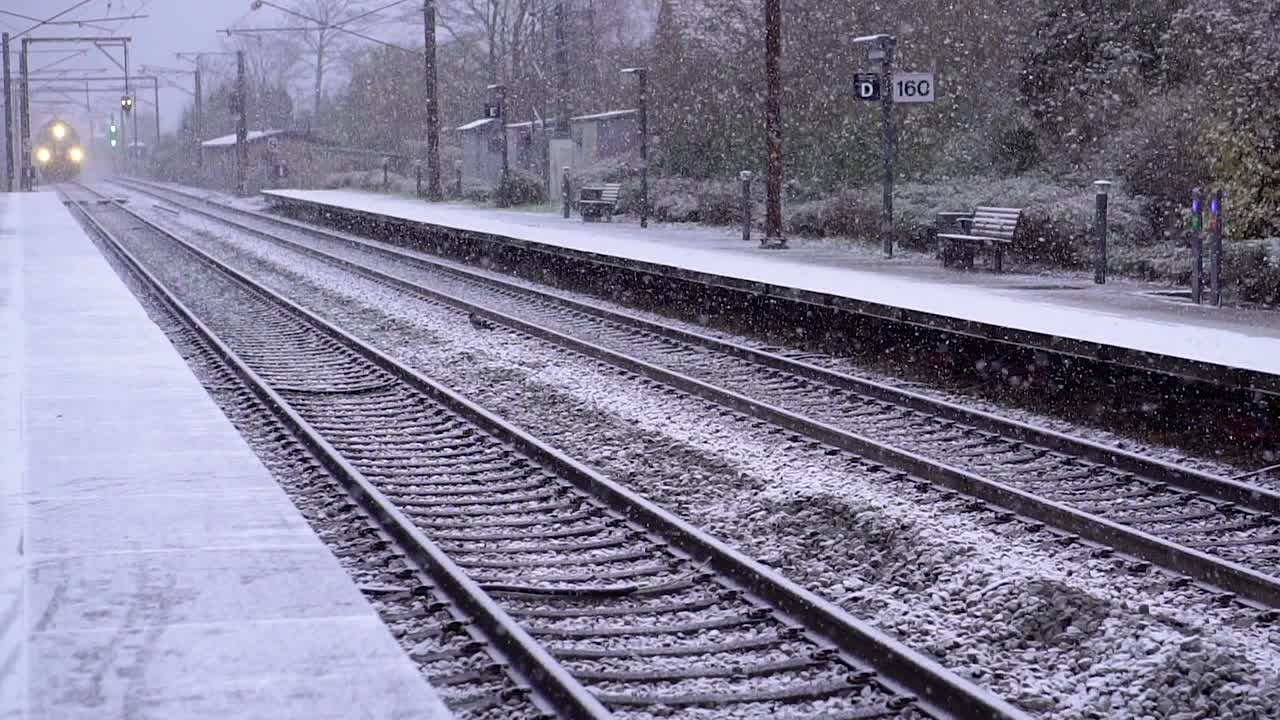 铁路。冬天的一天，一列火车驶近车站。视频下载