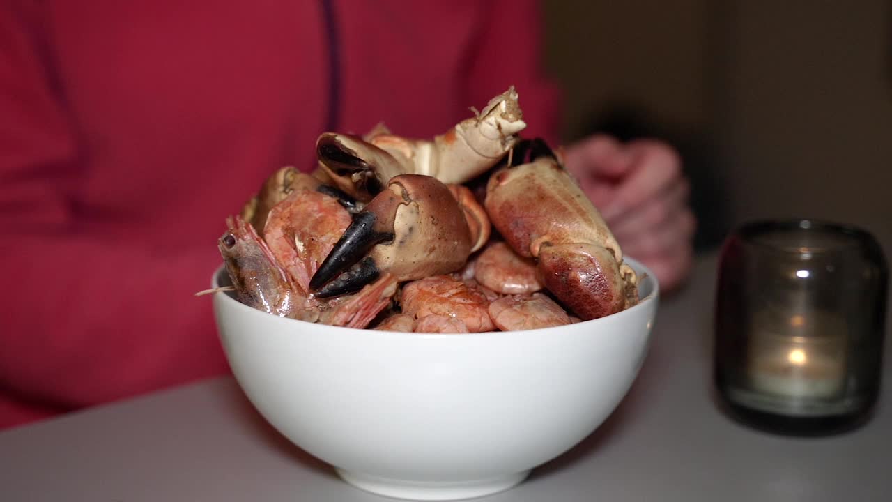 盘子里的煎蟹。女人的手能折断螃蟹。视频下载