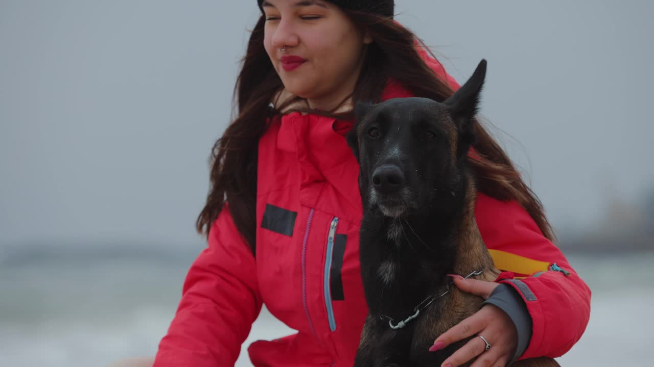 一个女人和她的狗坐在海边视频下载