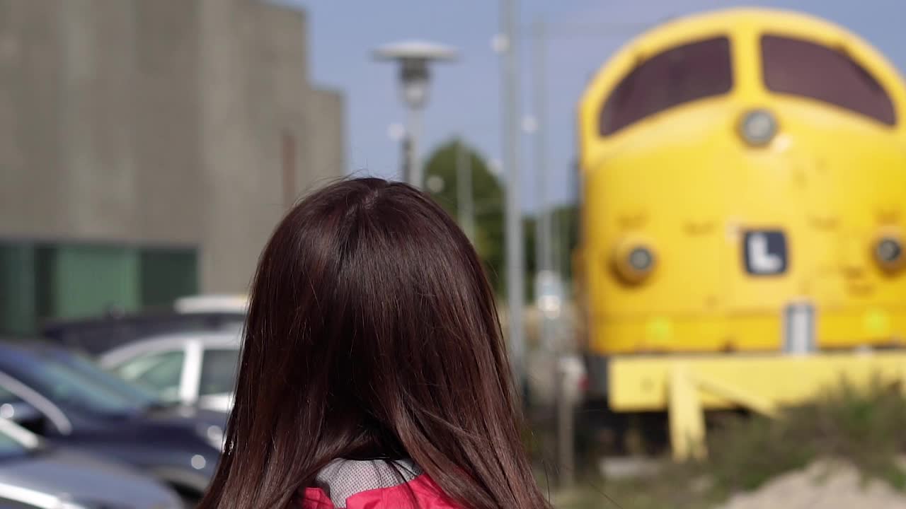 一个女人从后面走向火车。火车站。视频下载