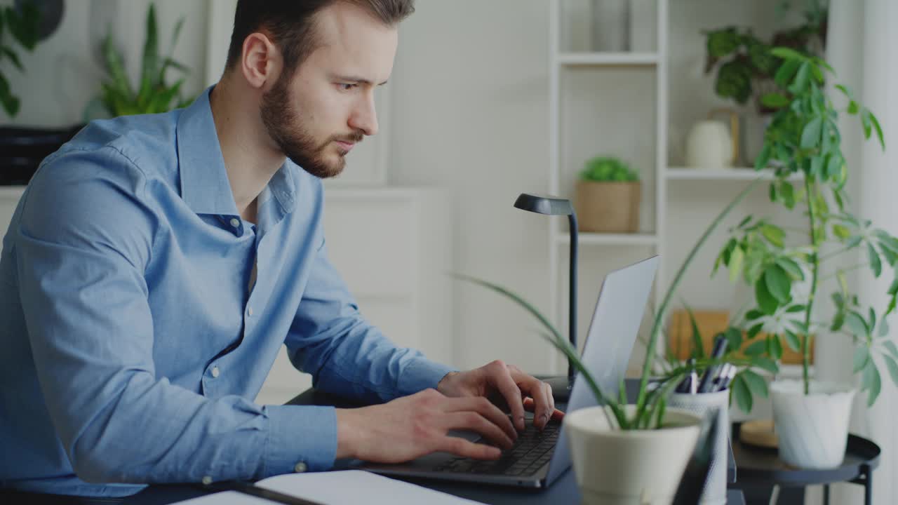 专注的男性企业家一边用笔记本电脑打字视频素材