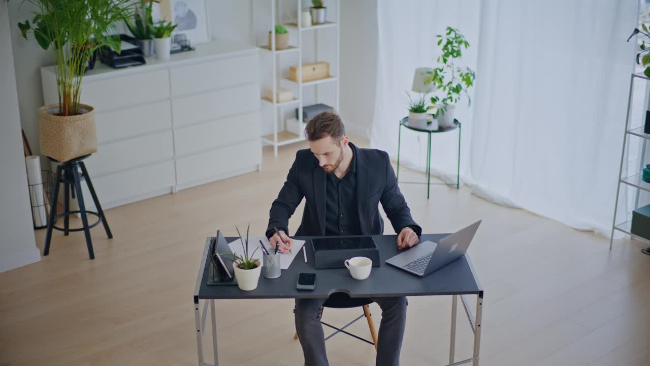 自信的商人在使用笔记本电脑时在纸上写策略视频下载