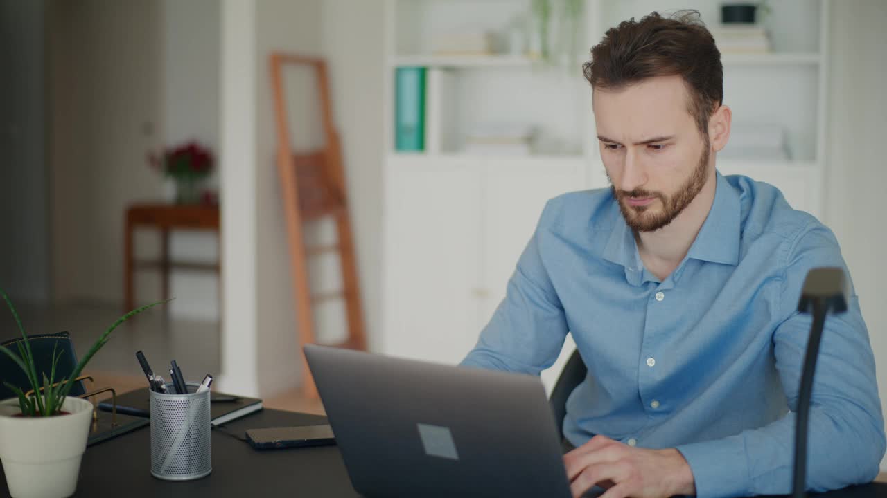 敬业的男性企业家在工作场所用笔记本电脑打字视频素材