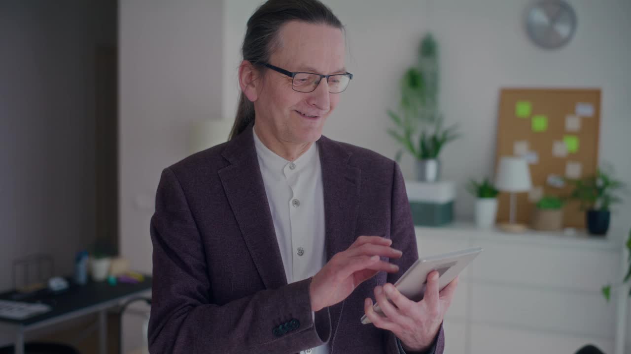 微笑的高级男性经理使用数码平板电脑视频下载