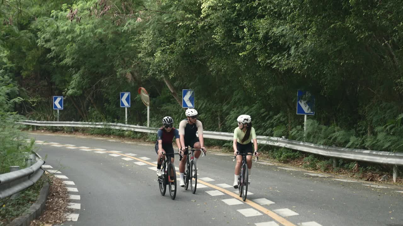 年轻的亚洲成年人在乡村道路上骑自行车视频下载