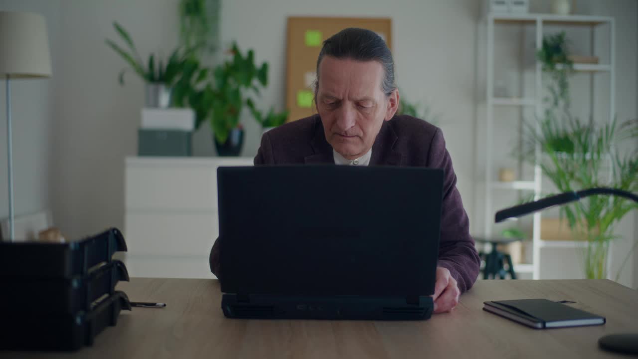 资深男性企业家在办公室使用笔记本电脑视频下载